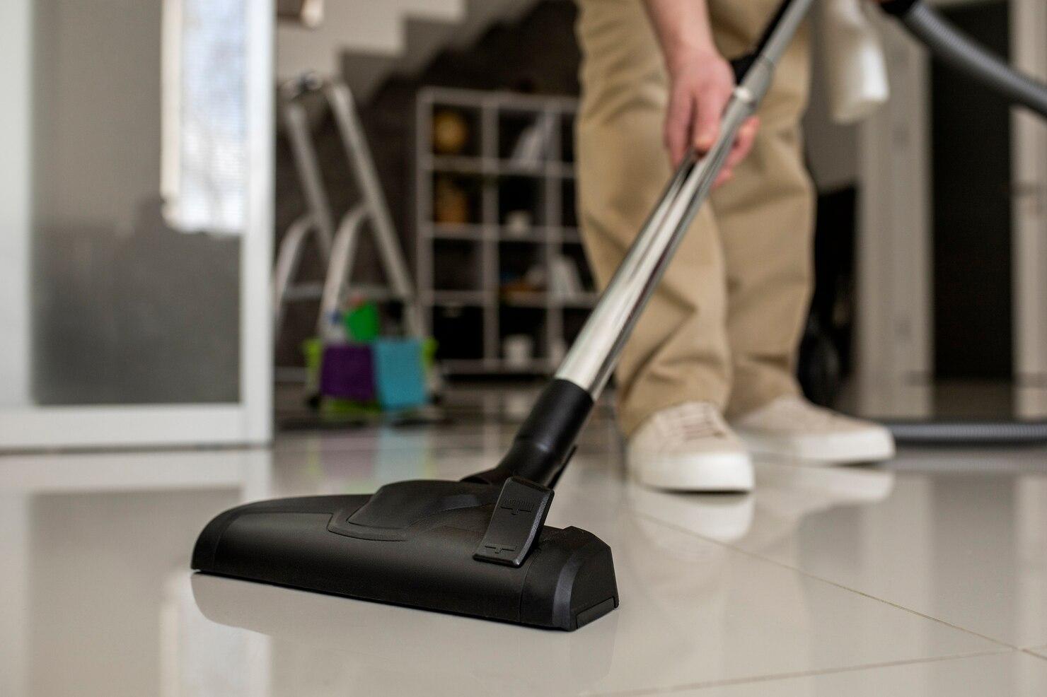 A person vacuuming the floor

Description automatically generated